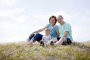 Familie sitzt auf einer Wiese