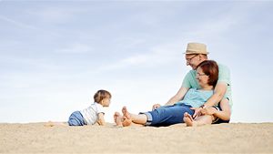 eine Familie mit Baby hat es sich im Sand gemütlich gemacht