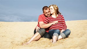 Pärchen sitzt im Sand